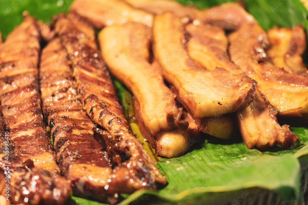 food concept. Grilled meat snack slices placed on banana leaf in Thailand fresh food market. Image with shallow depth of field