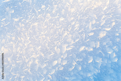 Beautiful gradient, winter natural background of ice and snow crystals illuminated by sun. 