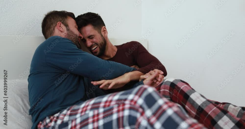 Young gay men couple having tender moment in the morning in bedroom and hugging each others at home - Homosexual love and lifestyle concept Young gay men couple having tender moment in the morning in bedroom and hugging each others at home - Homosexual love and lifestyle concept