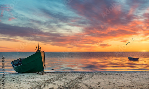 Anchored on sandy beach fishing boats near a small village of fishermen; here...