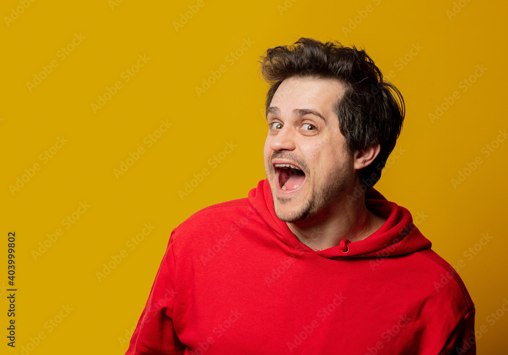 white smiling guy in red sweatshirt on yellow background white smiling guy in red sweatshirt on yellow background