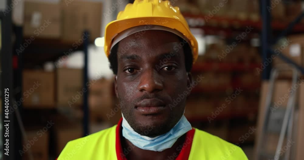 African worker man inside delivery boxes warehouse while wearing protective mask for coronavirus outbreak African worker man inside delivery boxes warehouse while wearing protective mask for coronavirus outbreak