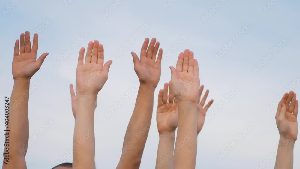 Teamwork. A group of people against the sky raises their hands up. The concept of voluntary voting, expression of consent, support for democracy. Teamwork. A group of people against the sky raises their hands up. The concept of voluntary voting, expression of consent, support for democracy.