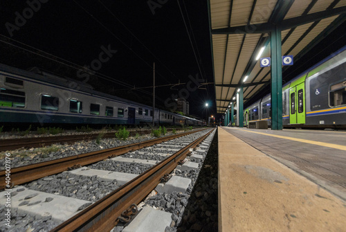 Railway station with train waiting on the tracks at night
