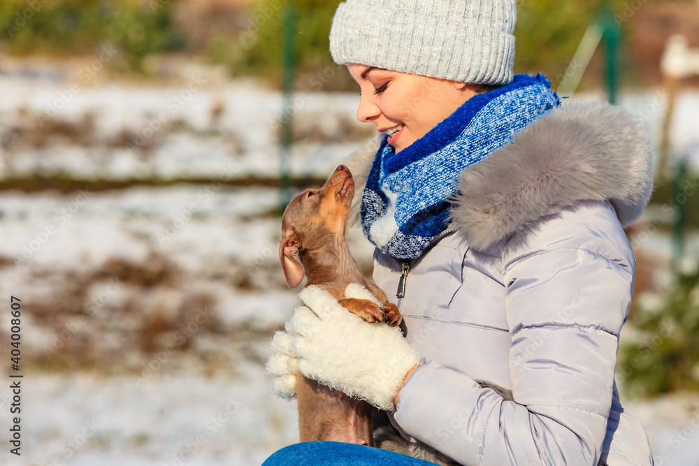 Woman playing with dog during winter Woman playing with dog during winter