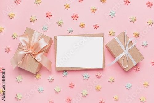 Gifts with note letter on isolated pink background with sweets, love and valentine concept © Daria Lukoiko
