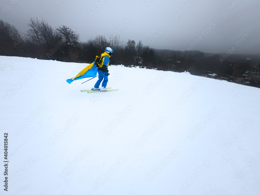 young woman skier sliding down by snowed slope