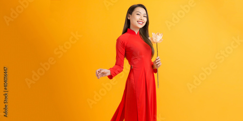 Portraits of cute lady with Vietnam culture traditional dress, Ao dai is famous and holding lotus flowers. photo