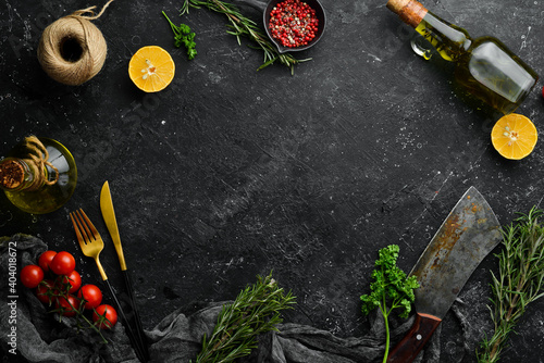 Black stone kitchen background. Kitchen board, vegetables and spices on a black background. Top view.