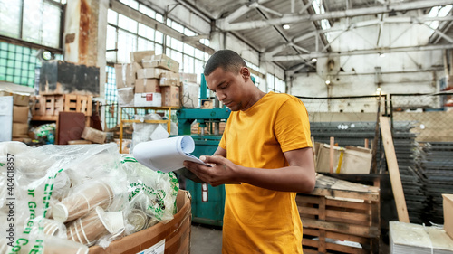 Young african american worker checking data about rubbish