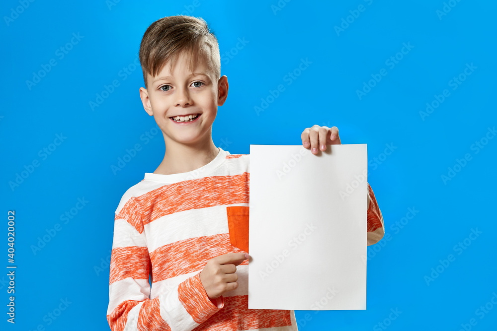 Boy in striped t-shirt points finger at blank paper Boy in striped t-shirt points finger at blank paper