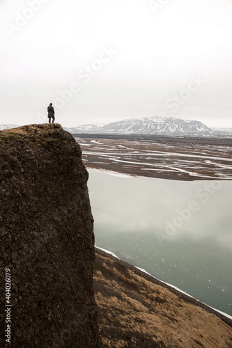 Tourist hiker person standing on massive panoramic rock cliff edge viewpoint Gaukshofdi at Thjorsa river in Iceland photo