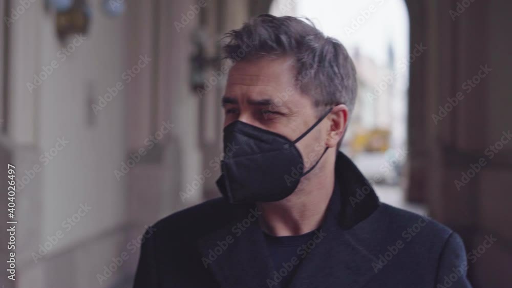 Man in medical mask walking on city street in Winter. Man in medical mask walking on city street in Winter.