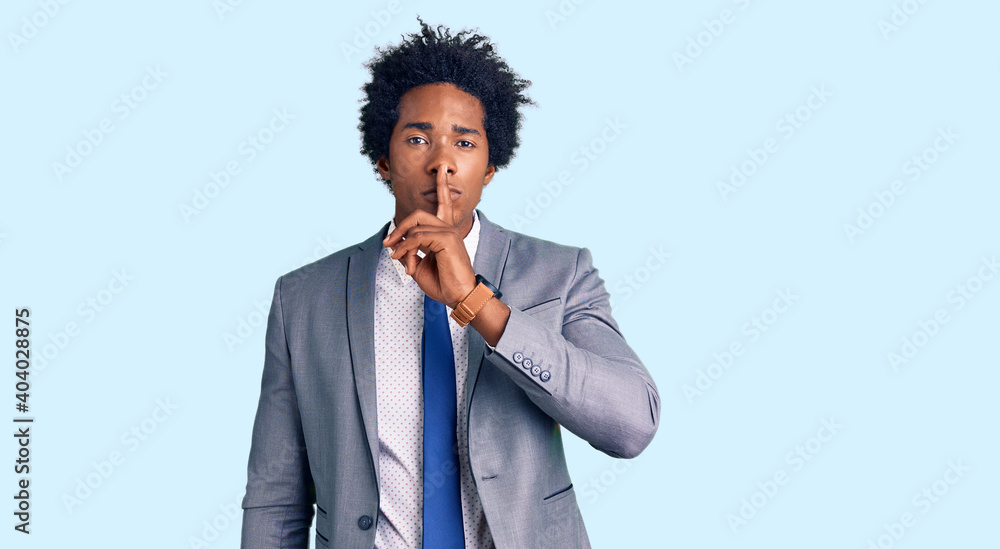 Handsome african american man with afro hair wearing business jacket asking to be quiet with finger on lips. silence and secret concept. Handsome african american man with afro hair wearing business jacket asking to be quiet with finger on lips. silence and secret concept.