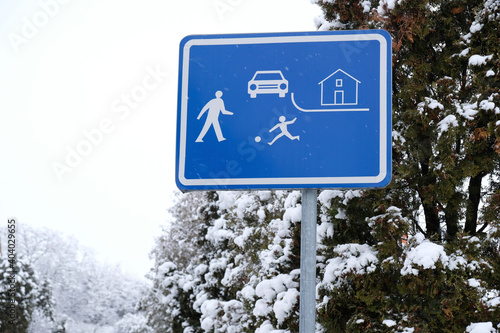 Snowy winter city landscape. Entry to the residence zone sign. Home zone entry road sign with trees and snow in the background. Residential District sign. House territory sign. Traffic regulations. 