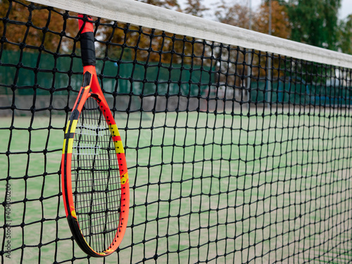 Tennis net and racket on outdoor tennis court © Valkantina