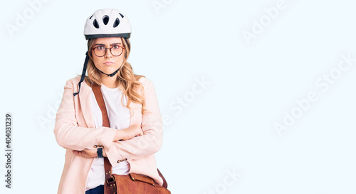 Young caucasian woman wearing bike helmet and leather bag skeptic and nervous, disapproving expression on face with crossed arms. negative person. © Krakenimages.com