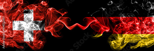 Switzerland  Swiss vs Germany  German  Deutschland smoky mystic flags placed side by side. Thick colored silky abstract smoke flags.