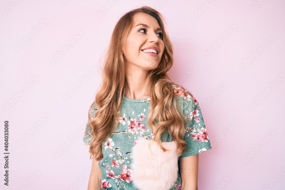 Young caucasian woman with blond hair wearing casual clothes looking away to side with smile on face, natural expression. laughing confident. Young caucasian woman with blond hair wearing casual clothes looking away to side with smile on face, natural expression. laughing confident.
