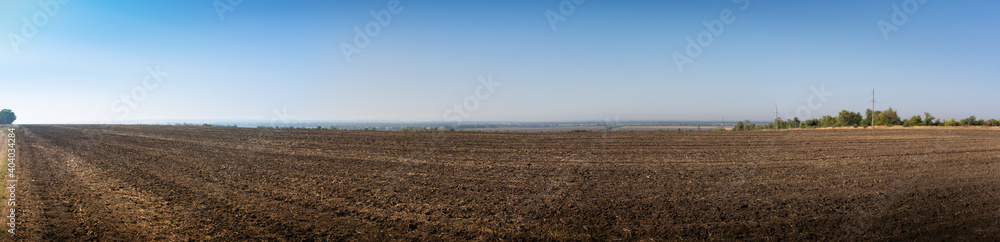 Panorama. Autumn landscape, black empty field after harvest on blue sky background Panorama. Autumn landscape, black empty field after harvest on blue sky background