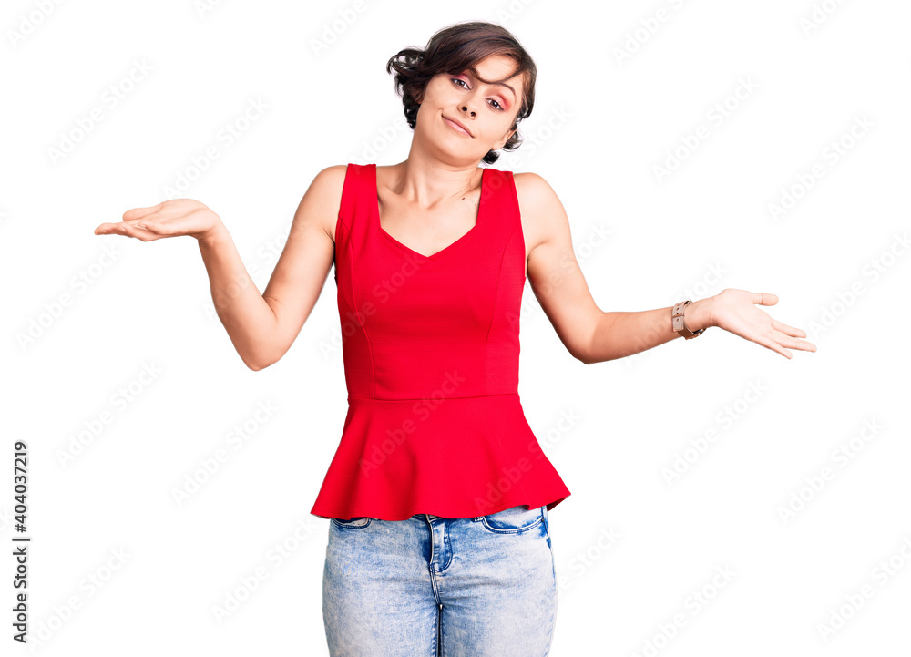Beautiful young woman with short hair wearing casual style with sleeveless shirt clueless and confused expression with arms and hands raised. doubt concept. Beautiful young woman with short hair wearing casual style with sleeveless shirt clueless and confused expression with arms and hands raised. doubt concept.