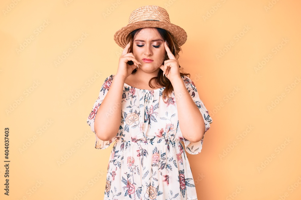 Young beautiful caucasian woman wearing summer dress and hat with hand on head for pain in head because stress. suffering migraine. Young beautiful caucasian woman wearing summer dress and hat with hand on head for pain in head because stress. suffering migraine.