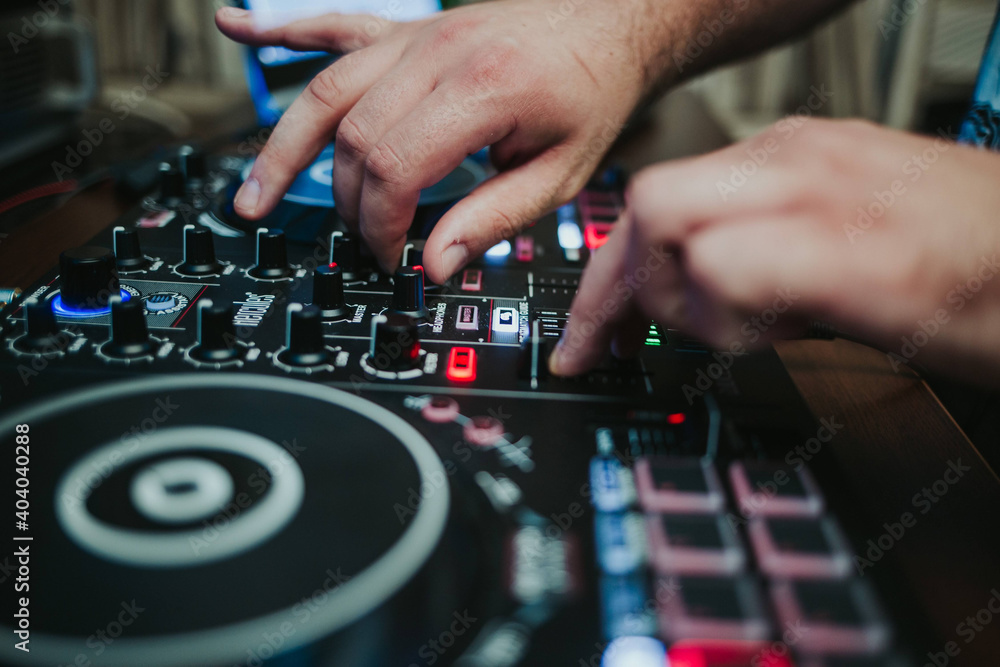 Closeup shot of a DJ's controller and his hands - obrazy, fototapety, plakaty 