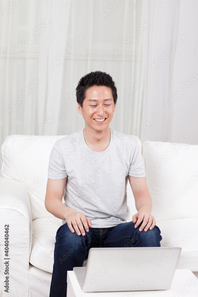 Cheerful businessman using a laptop computer in sofa Cheerful businessman using a laptop computer in sofa
