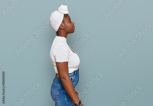 Fotografia Young african woman with turban wearing hair turban over isolated background looking to side, relax profile pose with natural face and confident smile