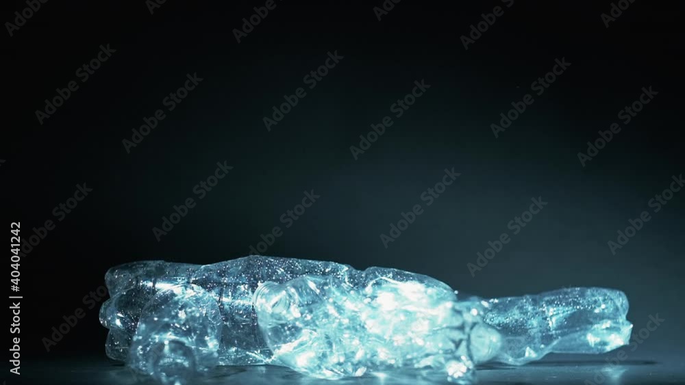 Zero waste. Biodegradable plastic. Climate change. Global warming. Empty used crushed eco bottles steaming up in air isolated on dark blue background. Zero waste. Biodegradable plastic. Climate change. Global warming. Empty used crushed eco bottles steaming up in air isolated on dark blue background.