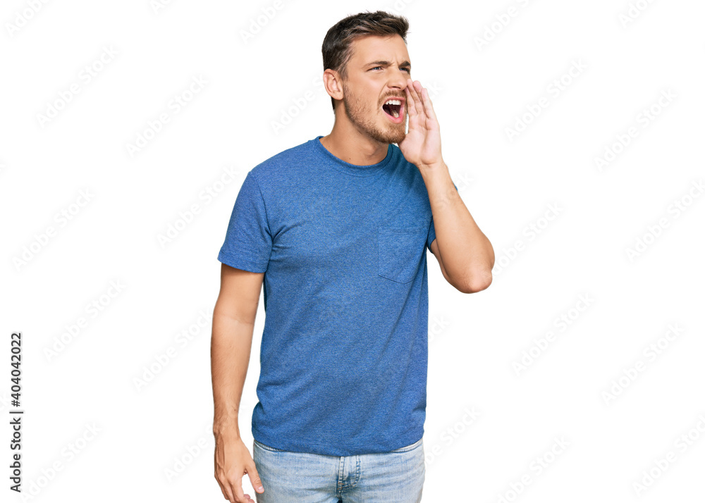 Handsome caucasian man wearing casual clothes shouting and screaming loud to side with hand on mouth. communication concept. Handsome caucasian man wearing casual clothes shouting and screaming loud to side with hand on mouth. communication concept.