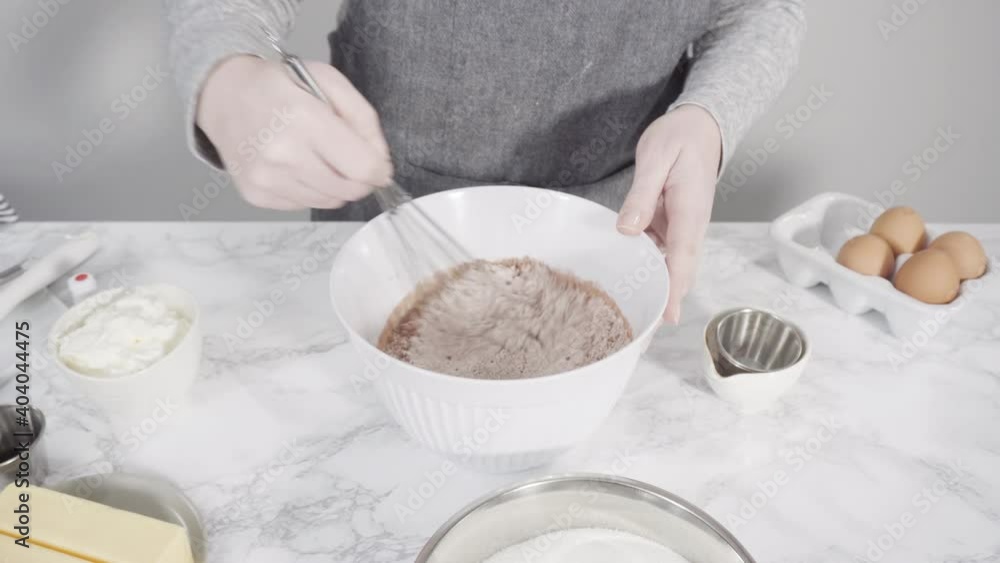 Step by step. Mixing wet ingredients in a glass mixing bowl to bake red velvet cupcakes. Step by step. Mixing wet ingredients in a glass mixing bowl to bake red velvet cupcakes.