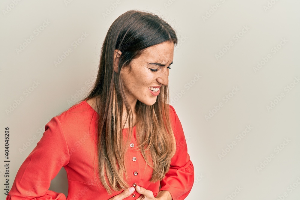 Young beautiful woman wearing casual clothes with hand on stomach because nausea, painful disease feeling unwell. ache concept. Young beautiful woman wearing casual clothes with hand on stomach because nausea, painful disease feeling unwell. ache concept.