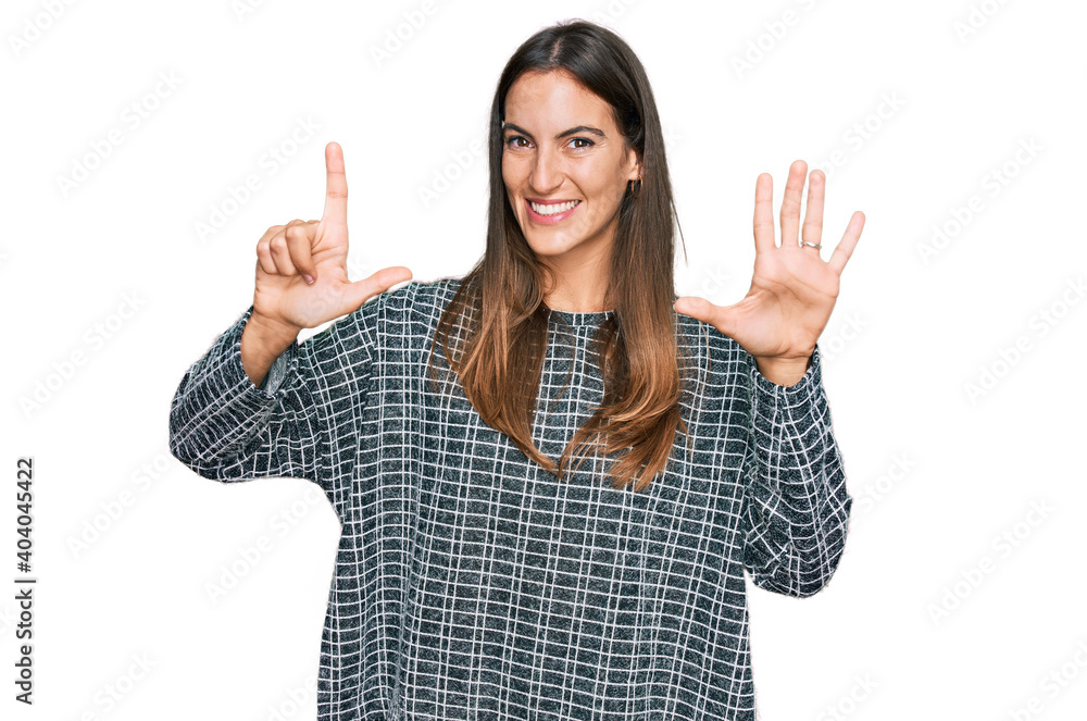Young beautiful woman wearing casual clothes showing and pointing up with fingers number seven while smiling confident and happy. Young beautiful woman wearing casual clothes showing and pointing up with fingers number seven while smiling confident and happy.