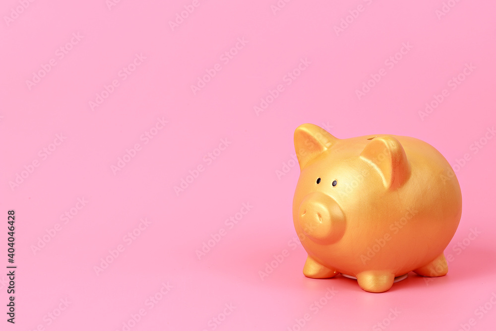 Close up of gold piggy bank on pastel pink background