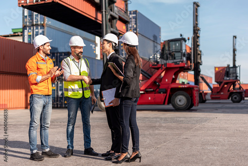 Obraz na płótnie group of businessman, Logistics engineer and inspector and businessman walking and discussing about business deal and project in shipping containerin commercial transport port w salonie