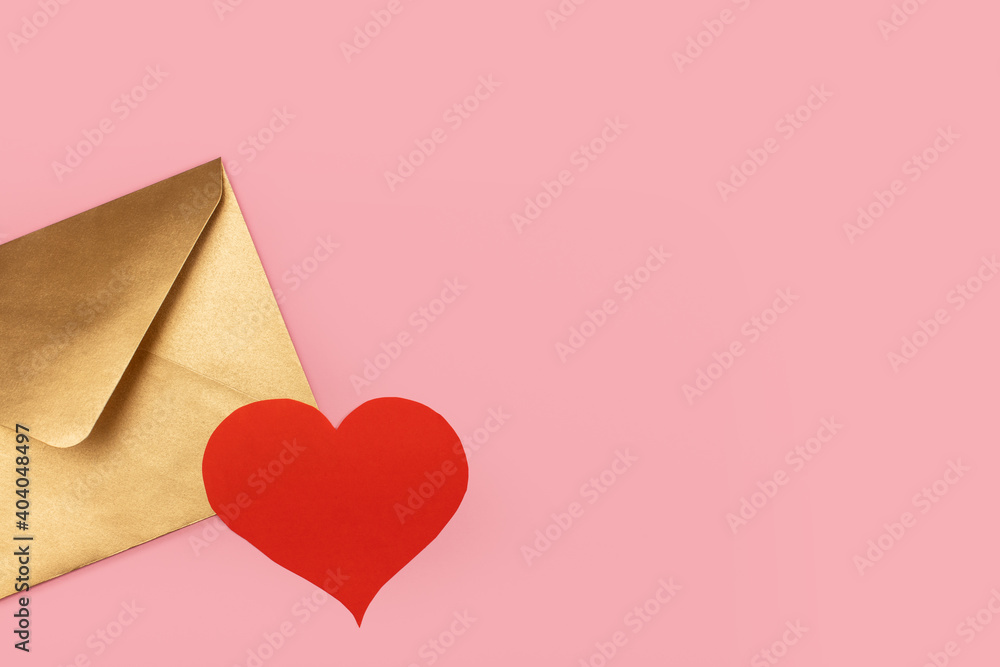 Golden paper envelope with red heart isolated on pink background