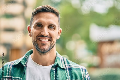 Young caucasian man smiling happy standing at the city.