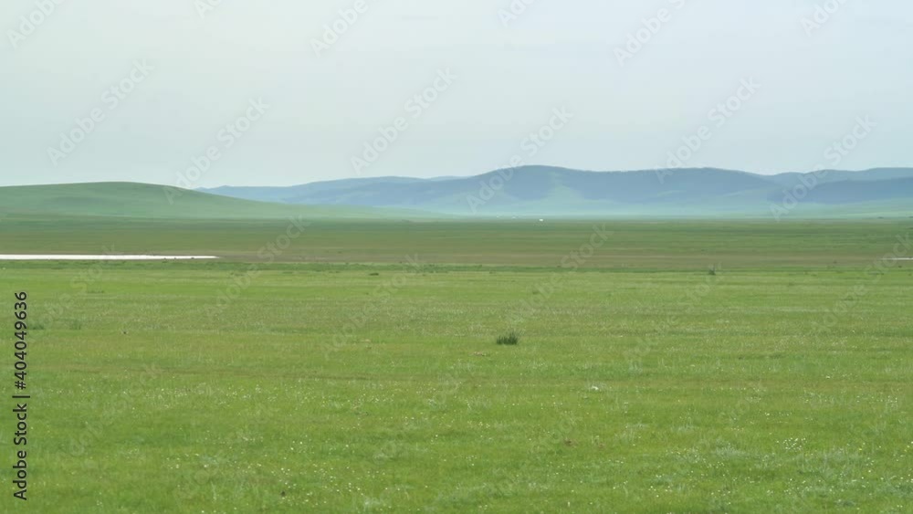 Little lake in treeless green plain.Grassland prairie meadow wold pasture steppe plateau tableland lowland mere lough wetland pond water lakeside lakeshore waterside littoral vast extensive Little lake in treeless green plain.Grassland prairie meadow wold pasture steppe plateau tableland lowland mere lough wetland pond water lakeside lakeshore waterside littoral vast extensive