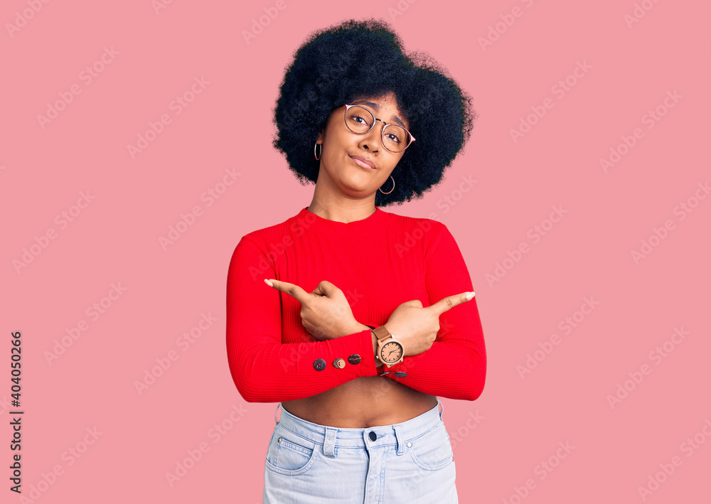 Young african american girl wearing casual clothes and glasses pointing to both sides with fingers, different direction disagree Young african american girl wearing casual clothes and glasses pointing to both sides with fingers, different direction disagree