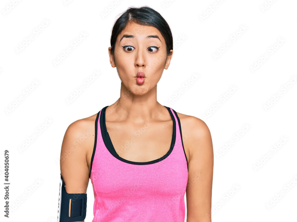 Beautiful asian young sport woman wearing sportswear and arm band making fish face with lips, crazy and comical gesture. funny expression. Beautiful asian young sport woman wearing sportswear and arm band making fish face with lips, crazy and comical gesture. funny expression.