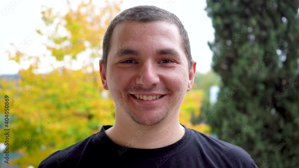 a guy with dark eyes and short hair smiles a guy with dark eyes and short hair smiles