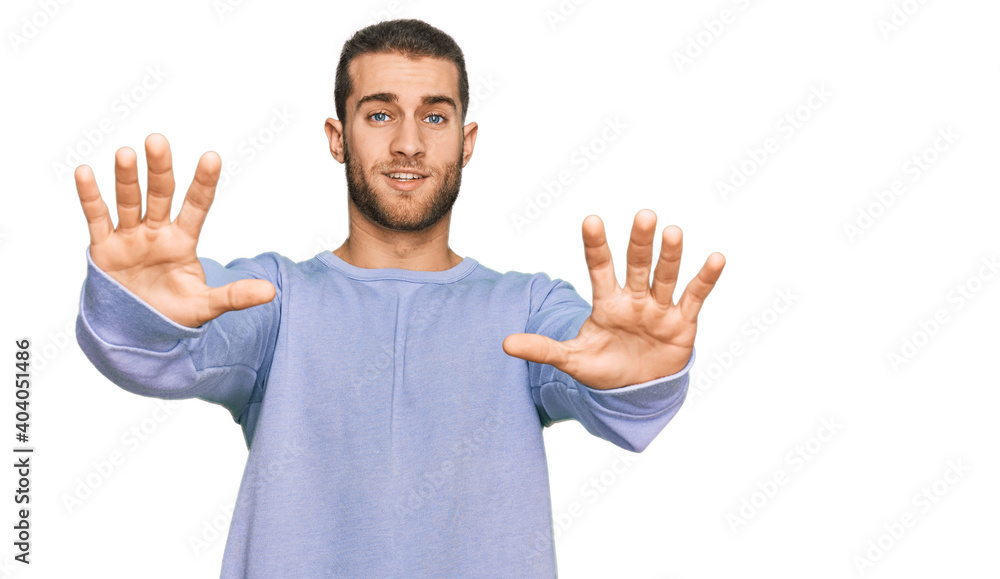 Young caucasian man wearing casual clothes afraid and terrified with fear expression stop gesture with hands, shouting in shock. panic concept. Young caucasian man wearing casual clothes afraid and terrified with fear expression stop gesture with hands, shouting in shock. panic concept.