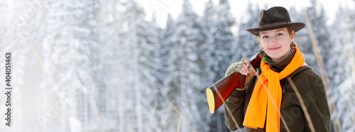Foto A young beautiful hunter woman on hunt in forest with rifle on the shoulder