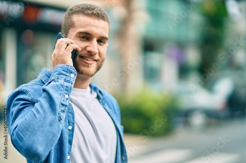 Young caucasian man smiling happy talking on the smartphone at the city.