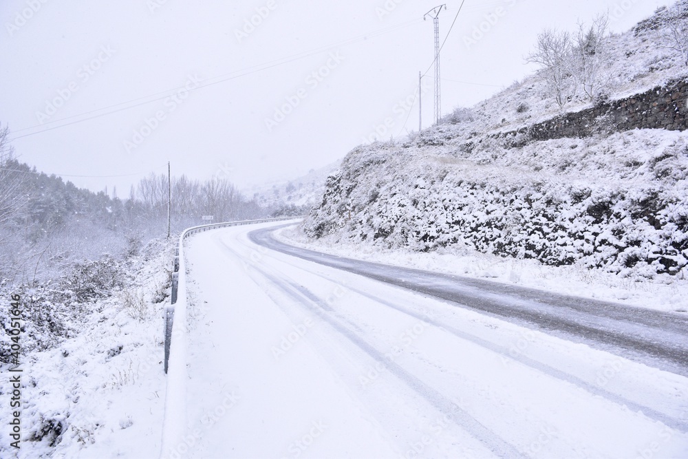 Road covered by snow in winter. Rolled cars on the road, Munilla, La Rioja.