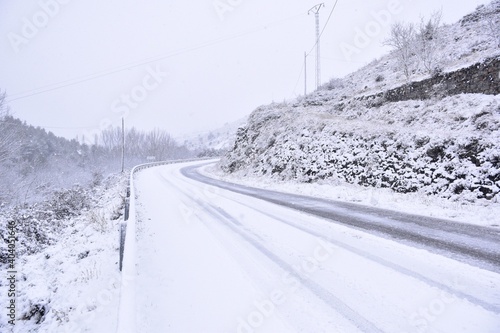 Road covered by snow in winter. Rolled cars on the road, Munilla, La Rioja. photo