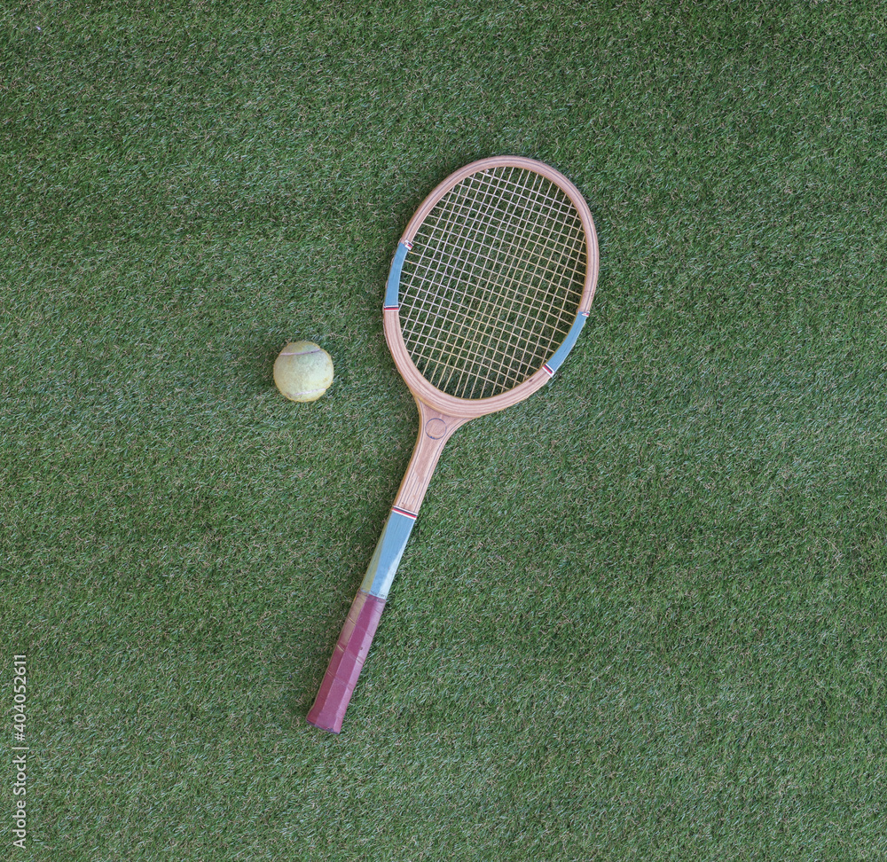 old wooden tennis racket isolated on green grass