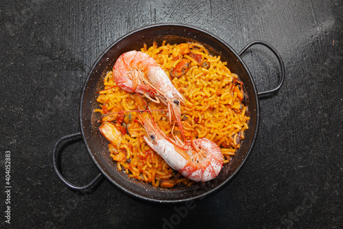 Fideua cooked in a paella with two prawns