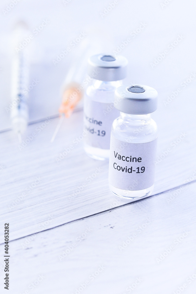 Close up of coronavirus vaccine and syringe on white background Close up of coronavirus vaccine and syringe on white background